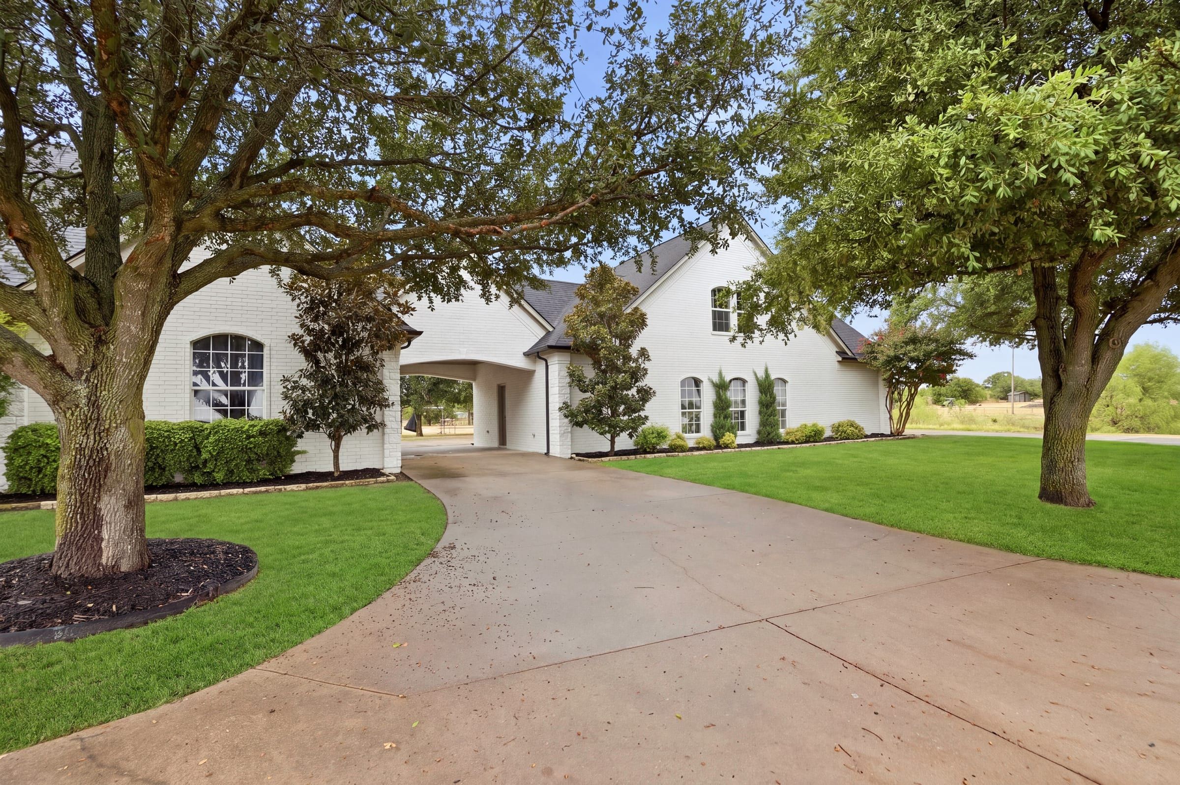 Mature trees and landscaping along the side drive